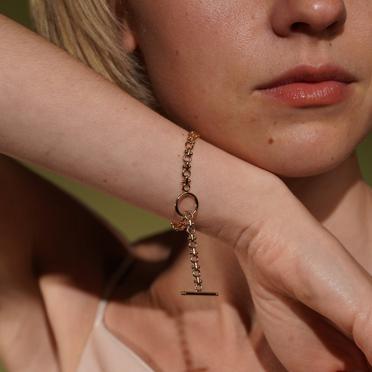 18k Gold plated chain bracelet with toggle T-bar clasp, worn on model's wrist.