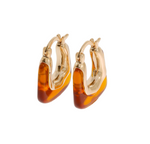 A pair of gold hoop earrings with organic, irregular translucent amber-colored inlays, shown on a plain white background.