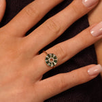 A close-up of a hand wearing Lucky Lady Ring in 18K Gold Plating Featuring Emerald-Coloured Baguette Cubic Zirconia and Clear Round Cubic Zirconia in an Art Deco Sunburst Design | Burren Jewellery