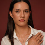 A close-up of model wearing Classic Cuteness Necklace and Ring in 18K Gold Plating with Round, Marquise and Pear Cut Cubic Zirconia Drop Pendant | Burren Jewellery
