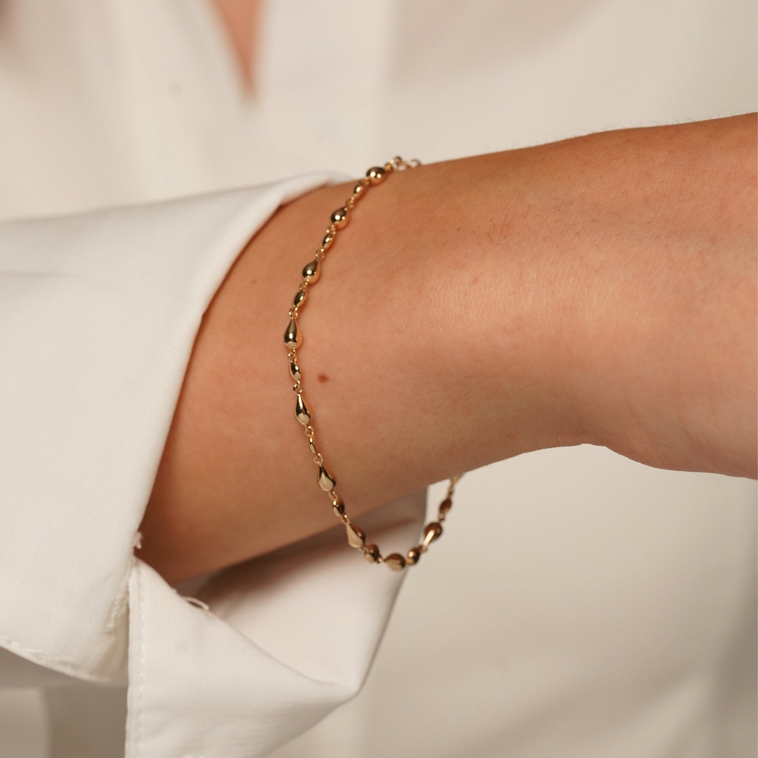 A close-up of Pink Lady Bracelet in 18K Gold Plating Featuring Alternating Polished Round and Teardrop Beads with an Adjustable Chain | Burren Jewellery