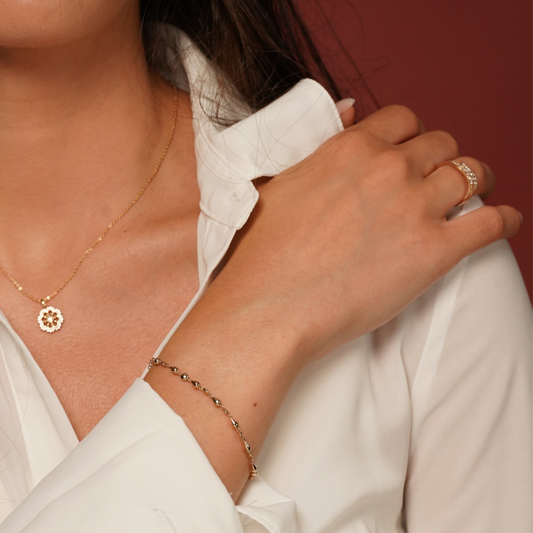 A close-up lifestyle shot of a woman wearing Pink Lady Bracelet in 18K Gold Plating Featuring Alternating Polished Round and Teardrop Beads with an Adjustable Chain | Burren Jewellery