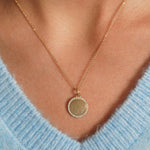 Closeup of model wearing Glamorous Goddess Necklace in 18K Gold Plating with Engravable Circular Disc Pendant Surrounded by Cubic Zirconia | Burren Jewellery