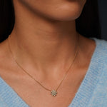 A close-up of a model wearing True Story Necklace in 18K Gold Plating Featuring a Floral-Inspired Marquise, Princess and Round-Cut Clear Cubic Zirconia Pendant on a Fine Gold Chain | Burren Jewellery
