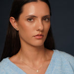 A close-up portrait of a model wearing True Story Earrings and Necklace in 18K Gold Plating Featuring Floral-Inspired Marquise, Princess and Round-Cut Clear Cubic Zirconia Stud Design | Burren Jewellery