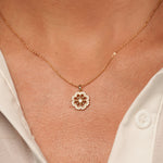 A close-up of a models's neck wearing Flower Garden Pendant Necklace in 18K Gold Plating Featuring a Floral Cubic Zirconia Pendant | Burren Jewellery