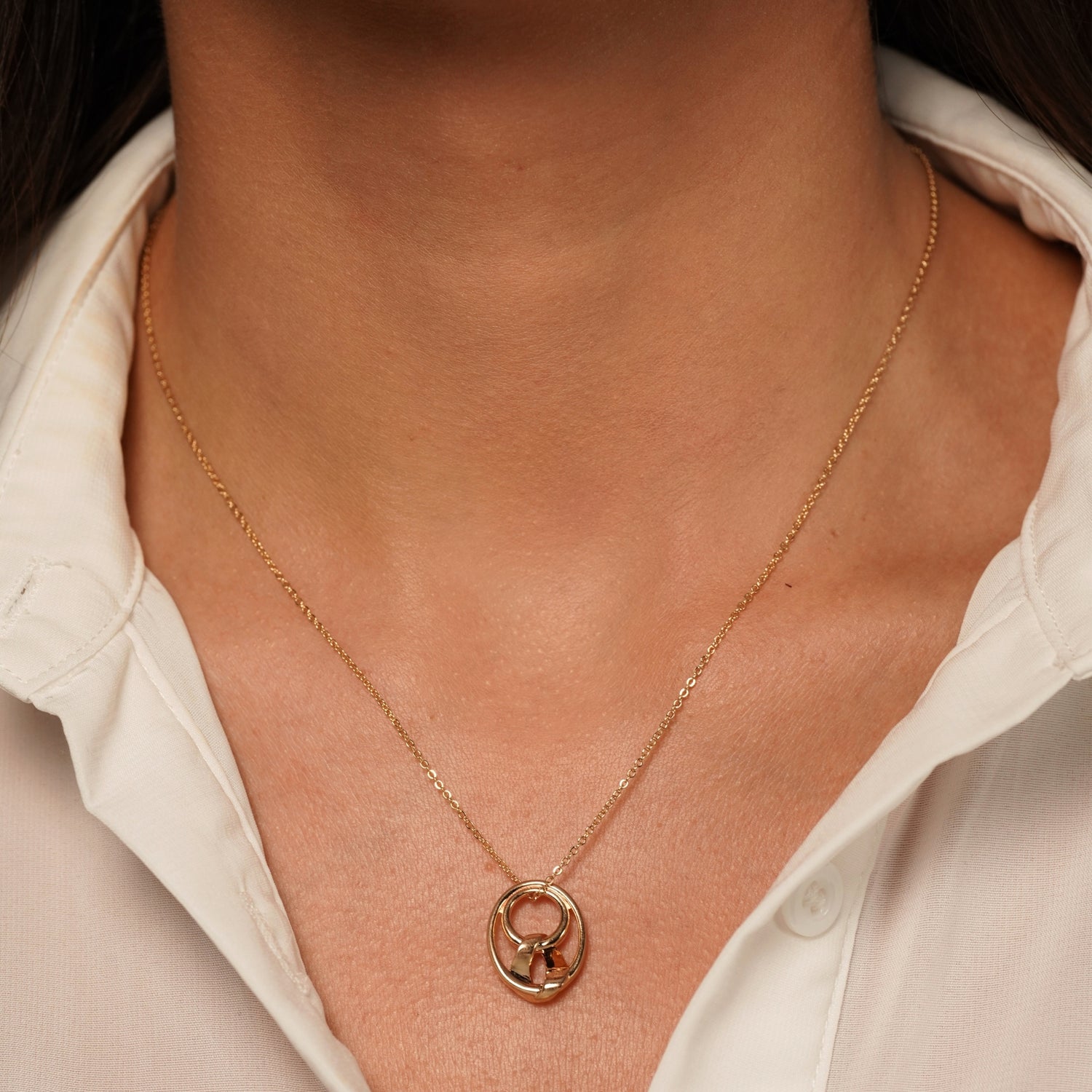 A close-up of a model's neck wearing Sweet Disaster Pendant Necklace in 18K Gold Plating with Abstract Intertwined Sculptural Pendant | Burren Jewellery