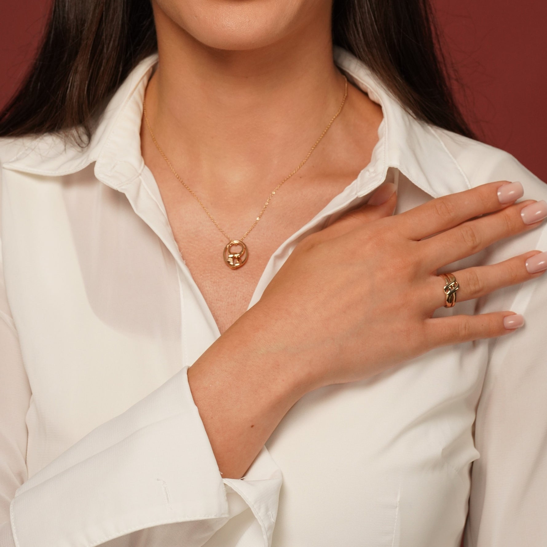 Model wearing Sweet Disaster Pendant Necklace in 18K Gold Plating with Abstract Intertwined Sculptural Pendant and Endless Knot Ring in 18k Gold Plating| Burren Jewellery