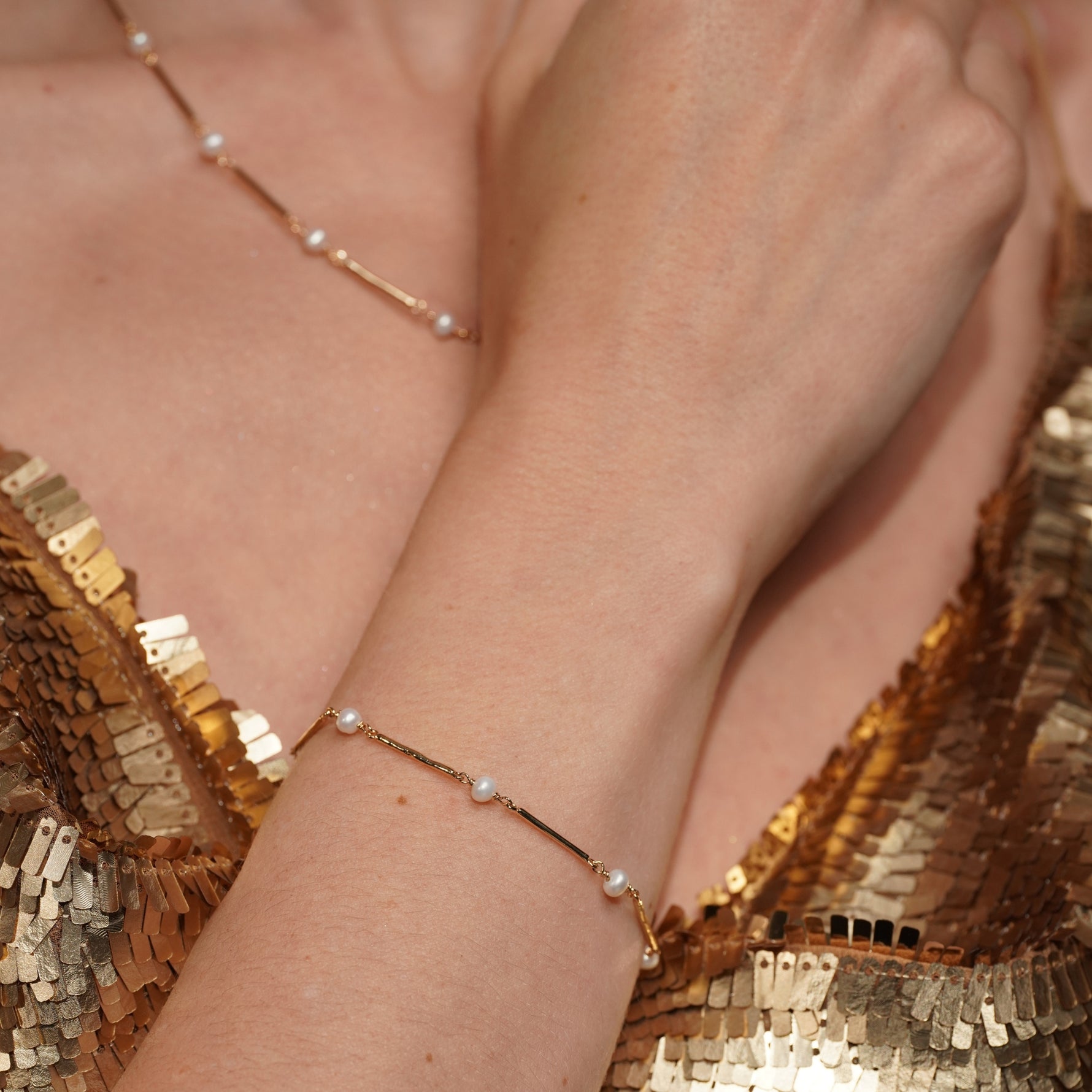 A close-up lifestyle shot of a model's Never Say Goodbye 18K Gold Plated Freshwater Pearl Bracelet and Necklace | Burren Jewellery