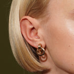Model wearing Dove Earrings in 18K Gold Plating Featuring a Sculptural Triple Interlocking Hoop Stud Design | Burren Jewellery