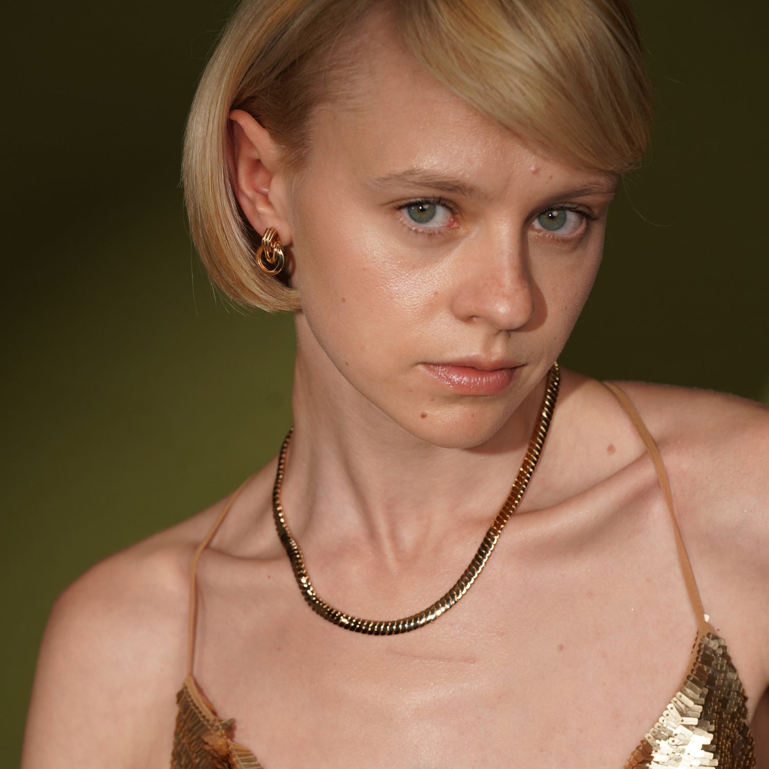 Model wearing the Black Honey gold plated ribbed chain necklace close to the collarbone, with hoop earrings visible