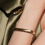 A close-up of a model's wrist wearing Paper Heart Chain 18K Gold Plated Chunky Flat Link Bracelet | Burren Jewellery
