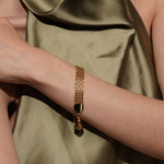 Model wearing the Devotion gold plated woven mesh bracelet flat against the wrist