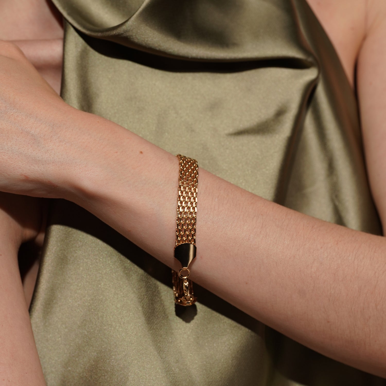 Model wearing the Devotion gold plated woven mesh bracelet flat against the wrist