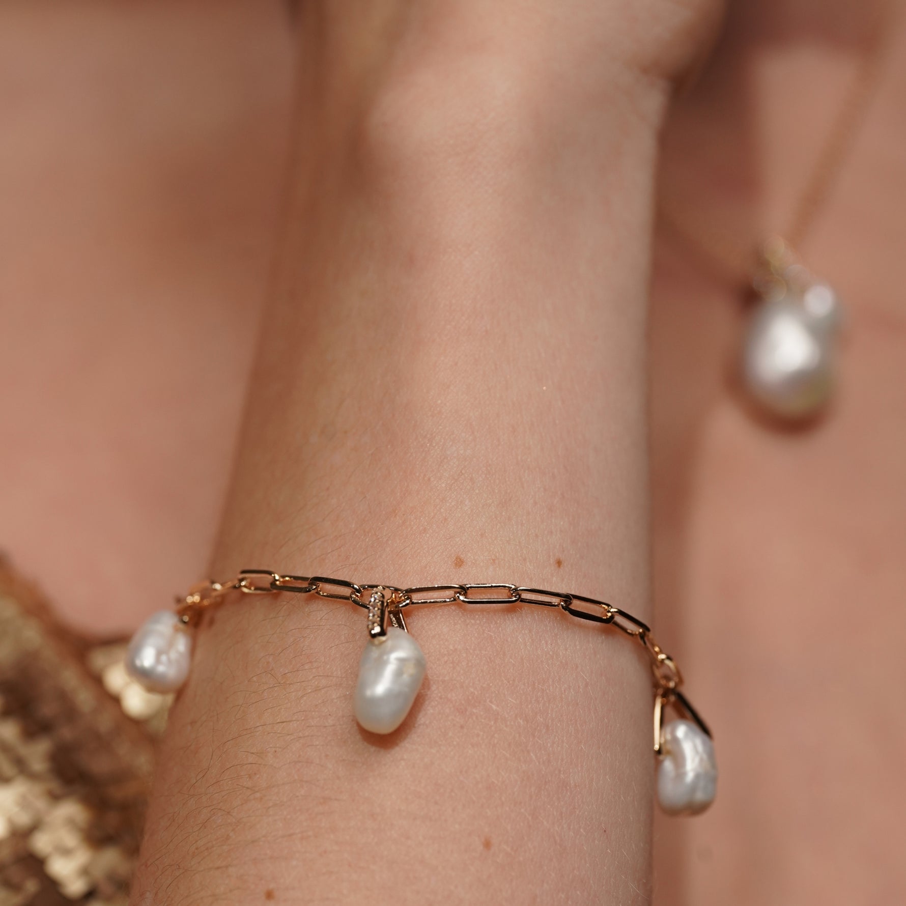 Model wearing the Sea Satin gold plated pearl bracelet, close up on the wrist
