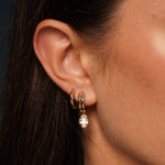 Close up of Model wearing in her ear Lily Huggies and Timeless Solitaire in 18K Gold Plating Featuring Smooth Polished Classic Hoop Earrings | Burren Jewellery