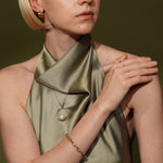 A close-up lifestyle shot of a model wearing Dirty Jazz 18K Gold Plated Classic Oval Link Chain Bracelet with Sea Lullaby necklace and Found my Home Ring  | Burren Jewellery