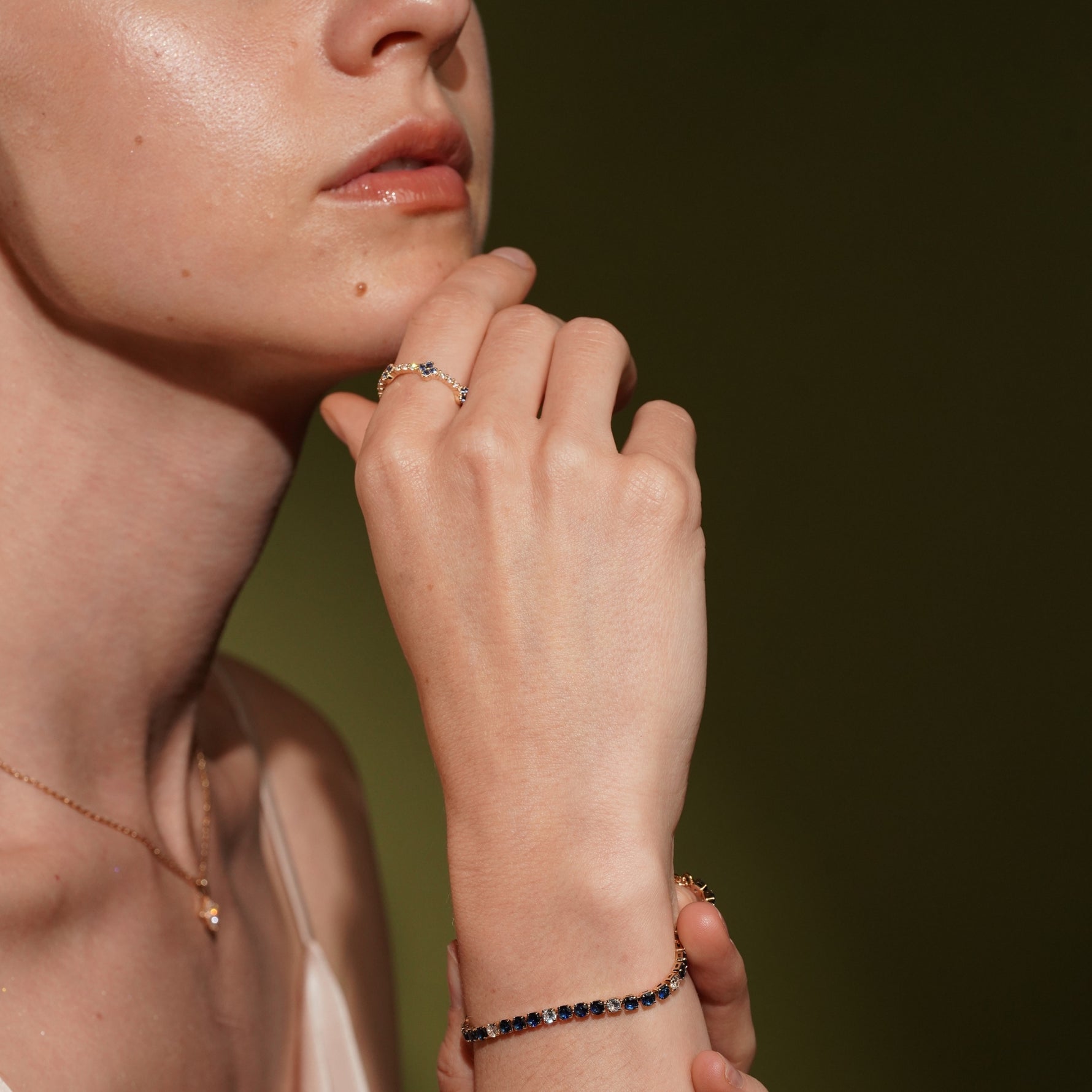 Close-up of a model wearing a delicate gold ring and No Apologies 18K Gold Plated Tennis Bracelet with Sapphire Blue and Clear Cubic Zirconia | Burren Jewellery