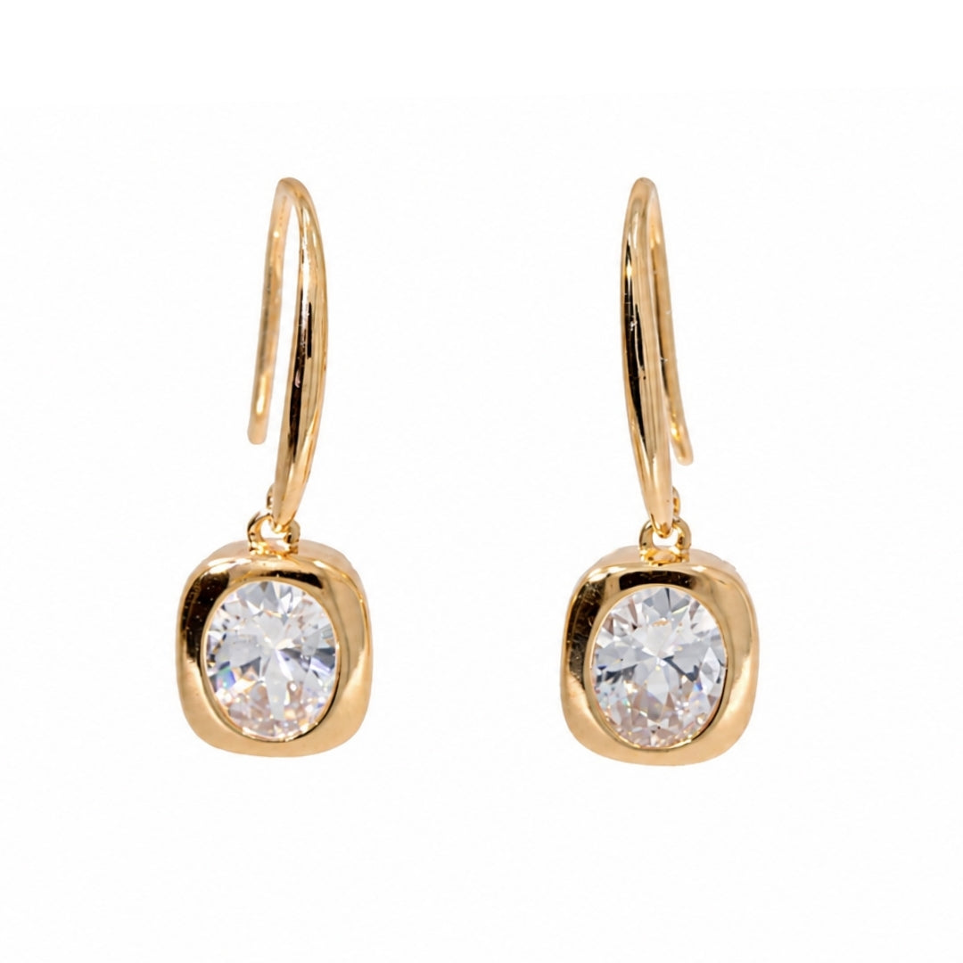A pair of gold drop earrings with a rounded bezel setting holding a clear round-cut gemstone, suspended from curved hook wires, shown on a plain white background.