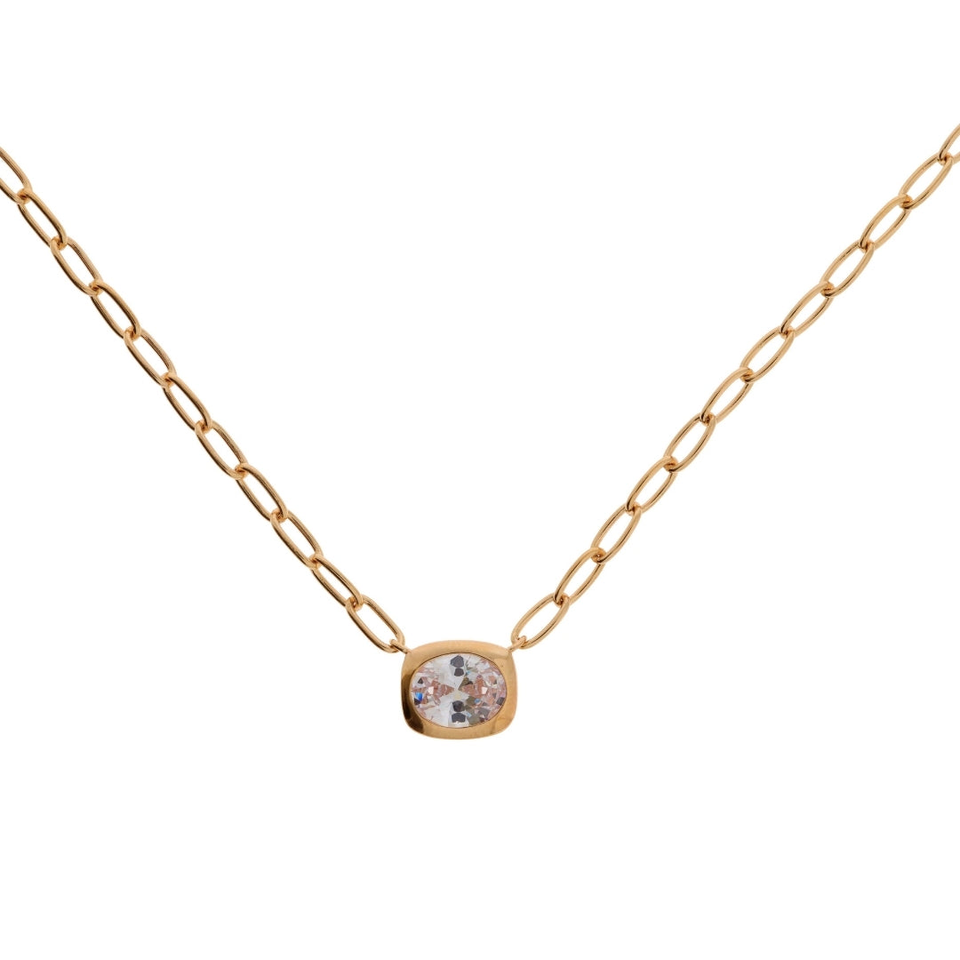 A delicate plated gold chain necklace with a small, bezel-set round clear gemstone pendant, displayed against a solid white background.