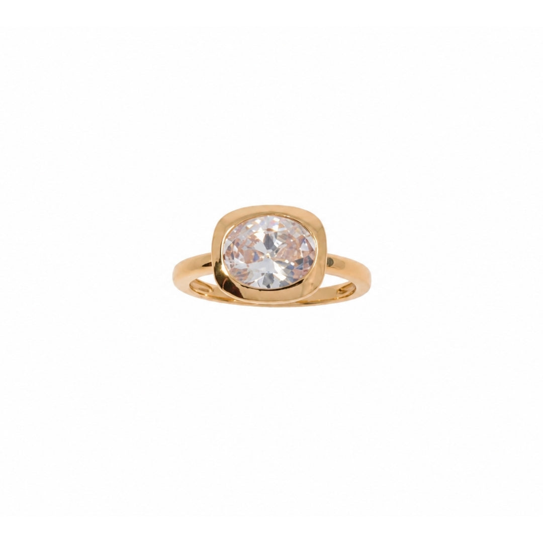 A gold ring with a bezel clear gemstone, shown against a plain white background.