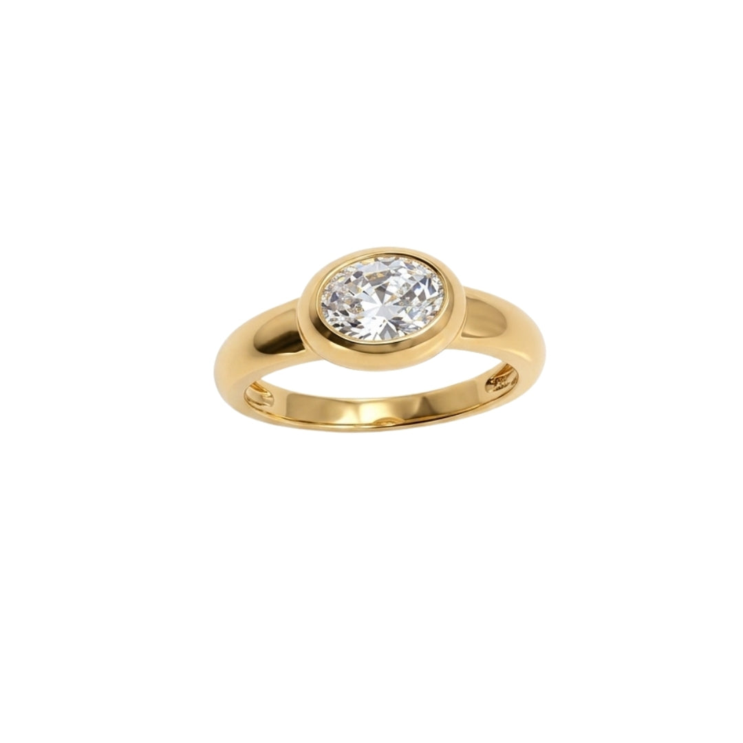 A yellow gold ring featuring a round-cut clear gemstone in a bezel setting, shown against a plain white background.