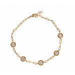 A gold chain bracelet with five evenly spaced round bezel-set clear gemstones on a white background.