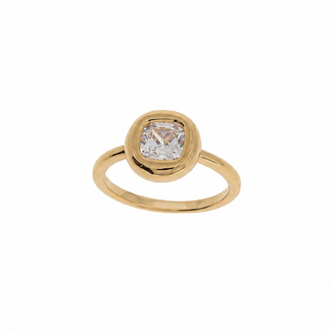 A gold ring featuring a cushion-cut clear gemstone in a bezel setting, shown against a plain white background.