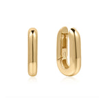 A pair of polished plated gold huggie hoop earrings, one shown from a side profile and the other from a front-three-quarter angle displaying the clasp mechanism, set against a clean white background with a soft reflection.