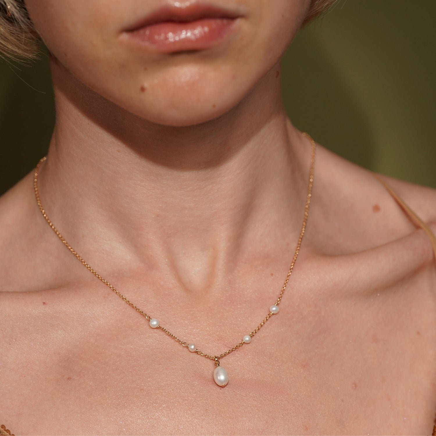 Model wearing the Tidekiss gold plated pearl necklace resting at the collarbone