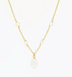 Tidekiss gold plated necklace laid flat, four station pearls and a larger centre drop natural pearl