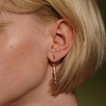 A close-up of a models's ear wearing Under the Sea 18K Gold Plated Fish Drop Earrings with Turquoise Beads | Burren Jewellery