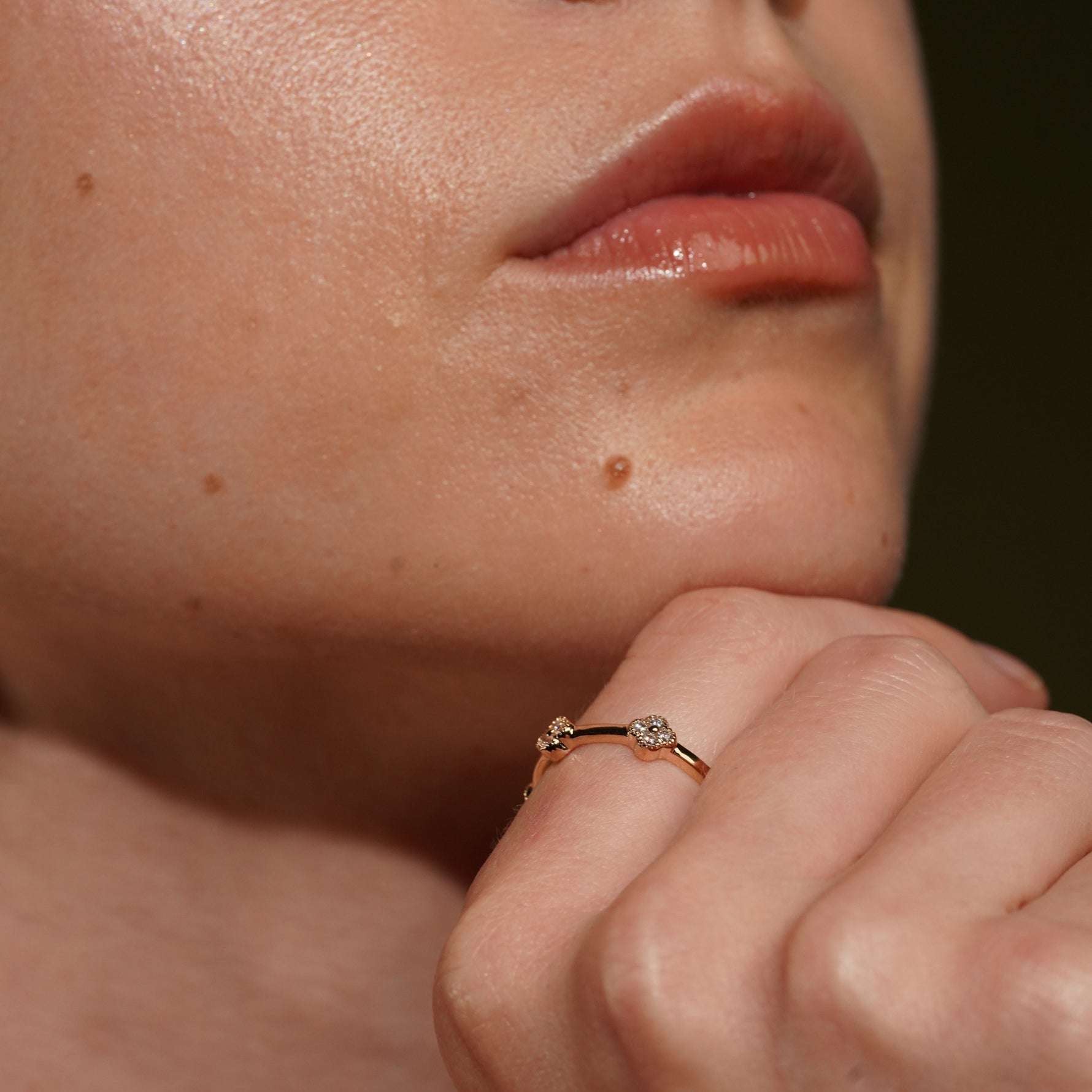 A close-up lifestyle shot of a model wearing Blossom Eternity Ring in 18K Gold Plating Featuring White Cubic Zirconia Quatrefoil Floral Motifs | Burren Jewellery