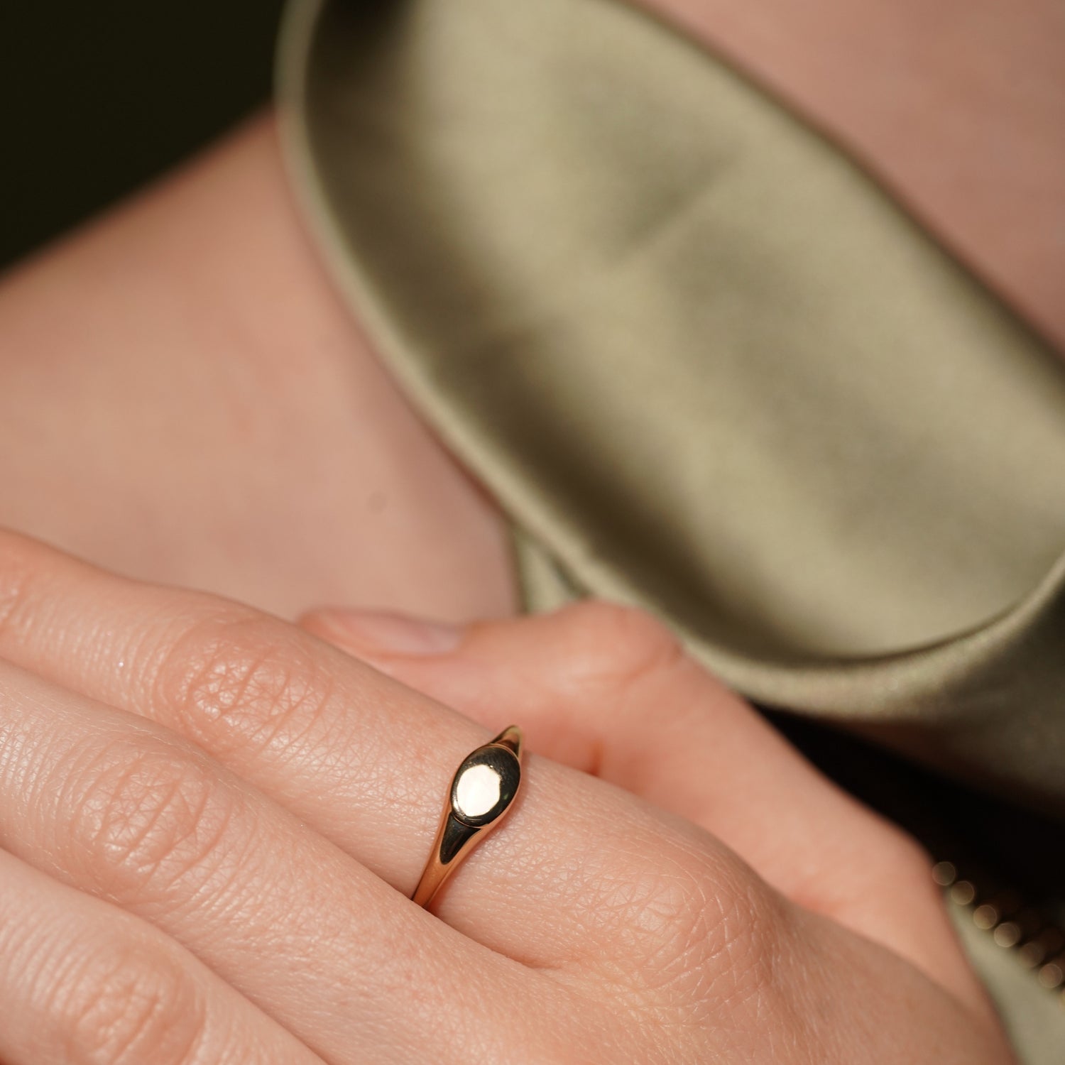 Model wearing the Soft Obsession gold plated signet ring, flat oval top facing the camera