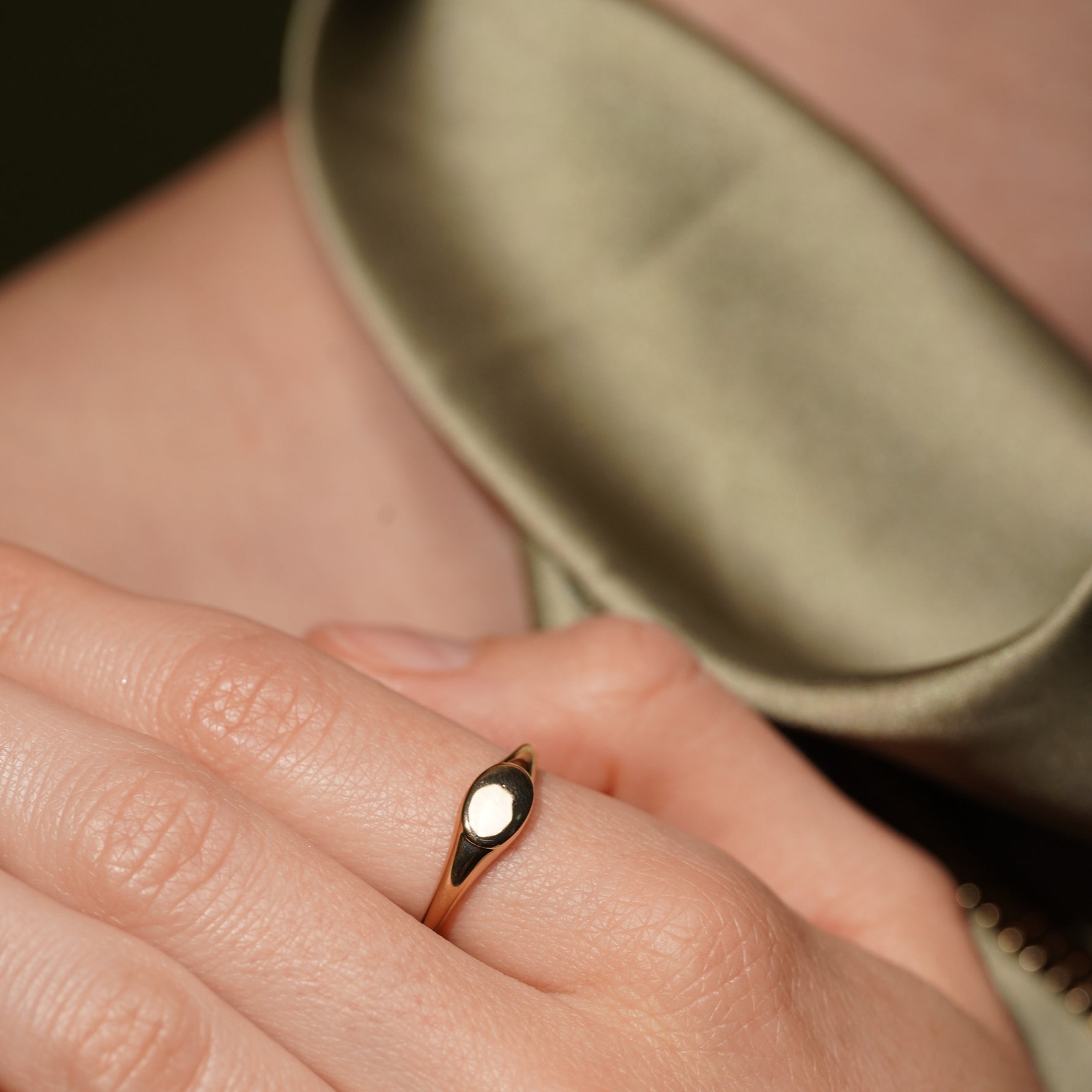 Model wearing the Soft Obsession gold plated signet ring, flat oval top facing the camera
