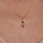 Model wearing Lingering Light Pendant in 18K Gold Plating Featuring an Oval Citrine-Coloured Cubic Zirconia with Round Amethyst-Coloured Cubic Zirconia Accents | Burren Jewellery