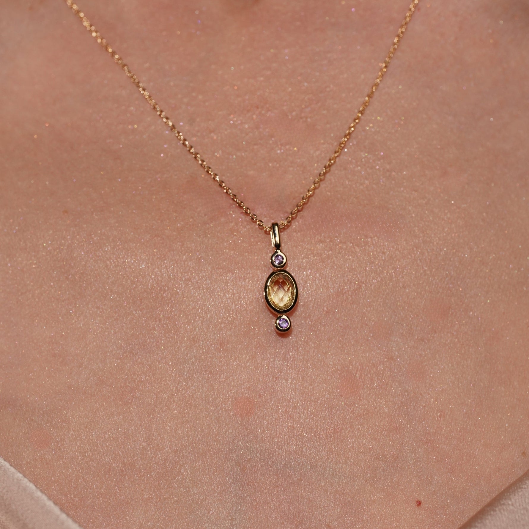 Model wearing Lingering Light Pendant in 18K Gold Plating Featuring an Oval Citrine-Coloured Cubic Zirconia with Round Amethyst-Coloured Cubic Zirconia Accents | Burren Jewellery