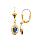 A pair of gold leverback earrings with oval blue gemstone charms, shown from front and side views against a plain white background.
