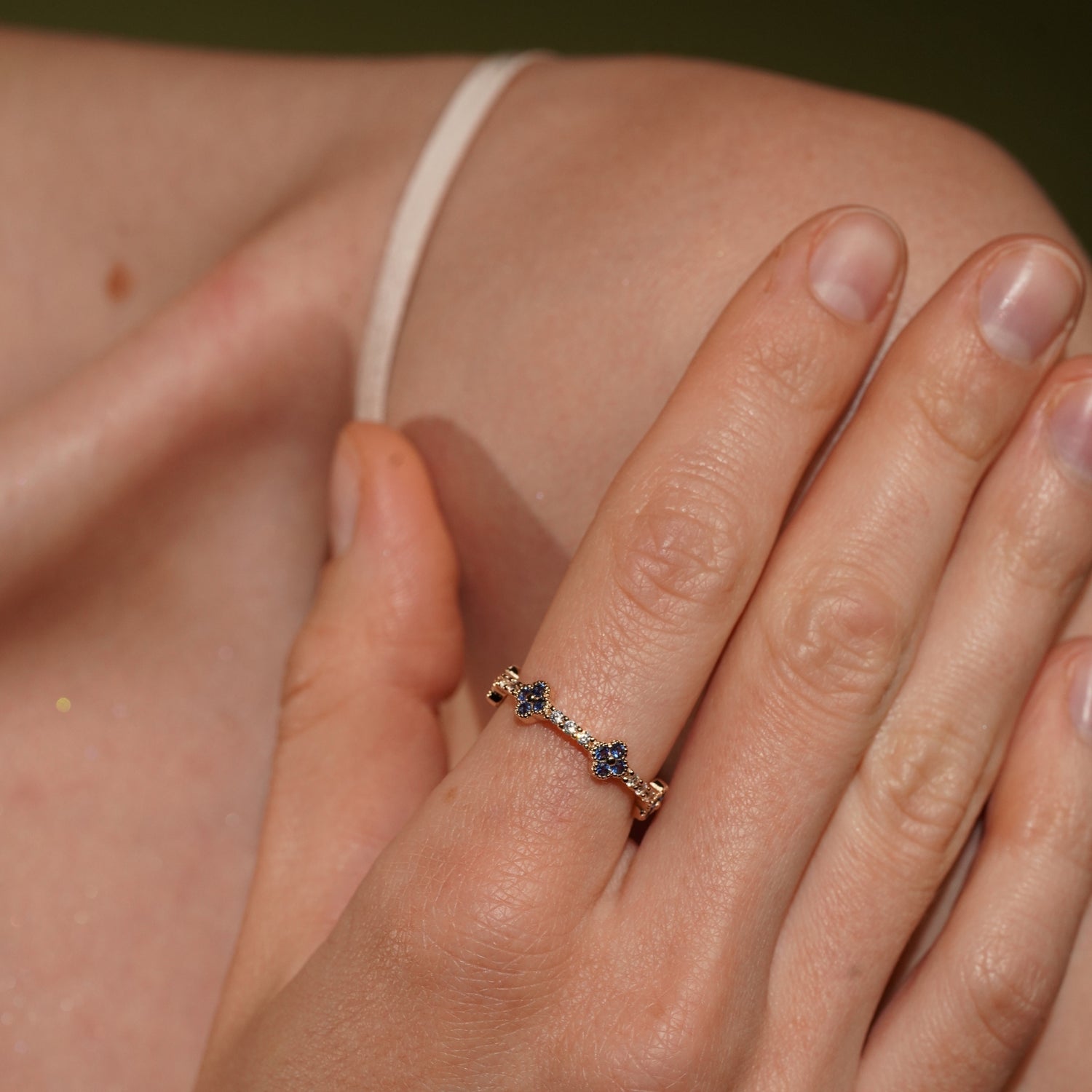 A close-up lifestyle shot of Tropical Blossom Ring in 18K Gold Plating Featuring Blue Quatrefoil Cubic Zirconia Motifs with White Pavé Cubic Zirconia Accents | Burren Jewellery