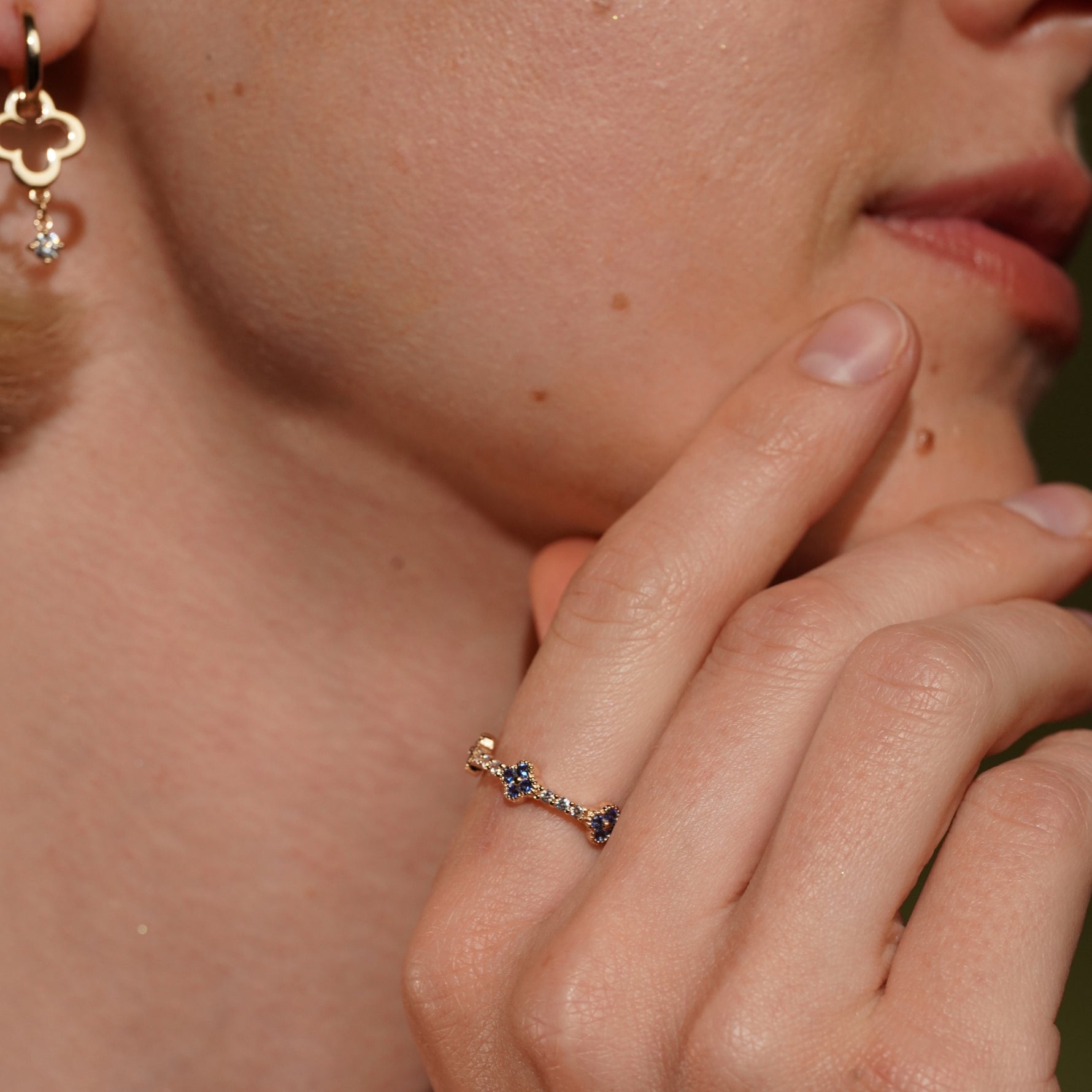 A close-up lifestyle shot of Tropical Blossom Ring in 18K Gold Plating Featuring Blue Quatrefoil Cubic Zirconia Motifs with White Pavé Cubic Zirconia Accents | Burren Jewellery