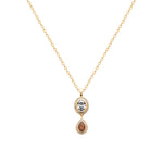 A gold chain necklace with a double-drop pendant featuring a round light blue gemstone and a teardrop-shaped reddish-brown gemstone, both surrounded by small clear stones, on a plain white background.