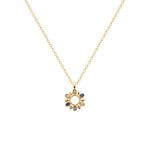 Gold necklace with a circular pendant featuring blue stones on a white background