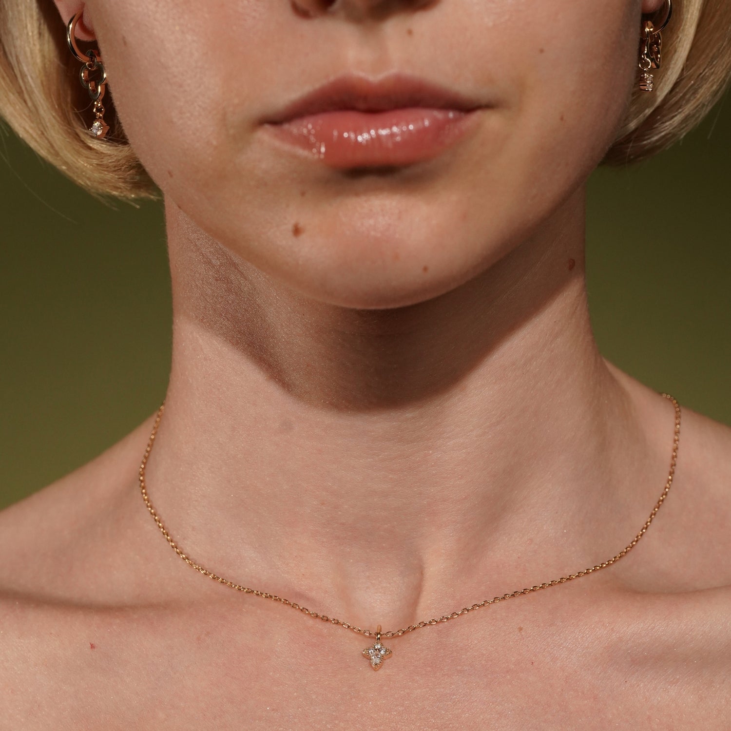 Close-up of a model's neck and lower face wearing Deep Breath Pendant in 18K Gold Plating with Round and Marquise-Cut Cubic Zirconia on a Fine Trace Chain | Burren Jewellery
